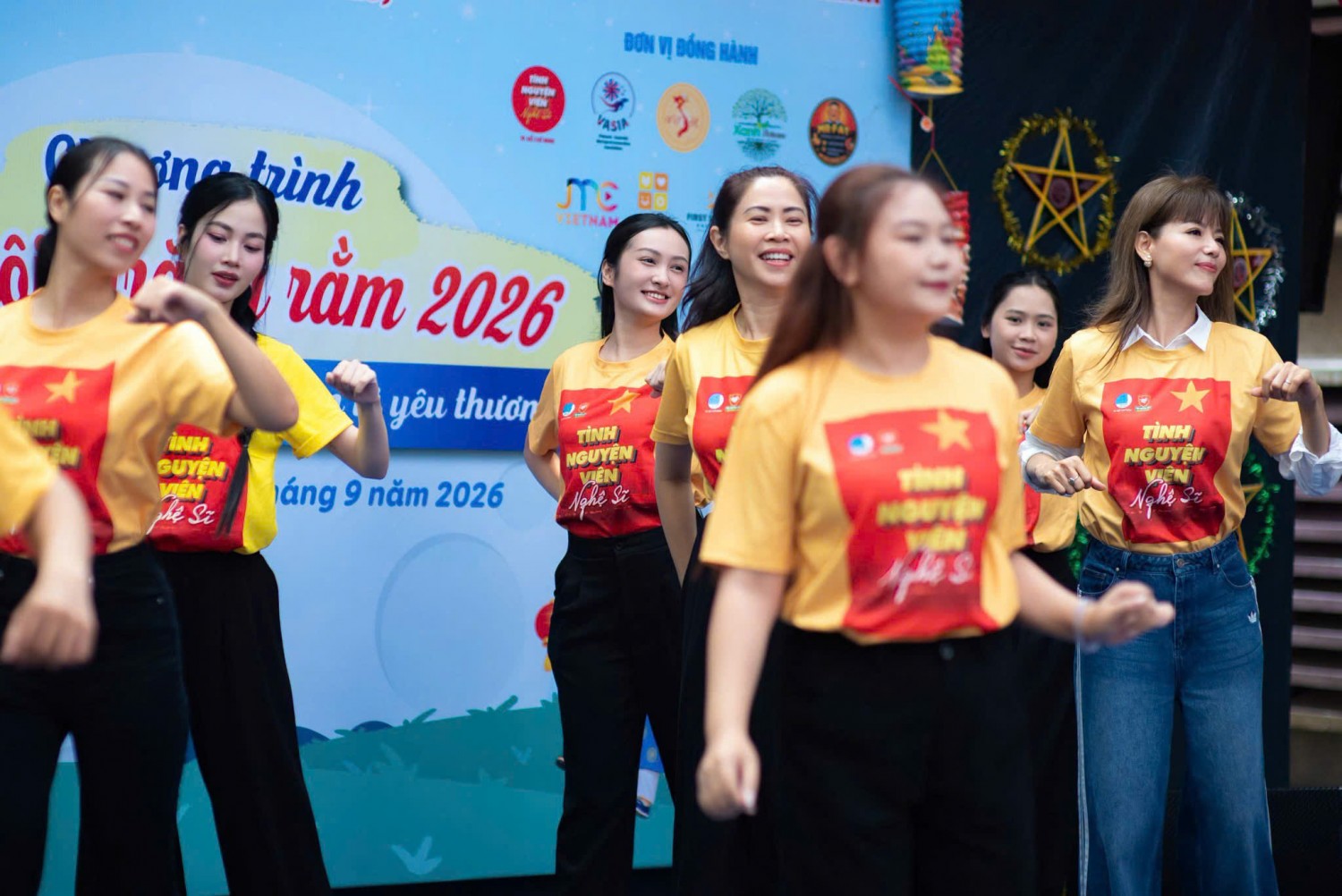Tình nguyện viên nghệ sĩ mặc áo thun cổ tròn màu vàng biểu diễn trong sự kiện
