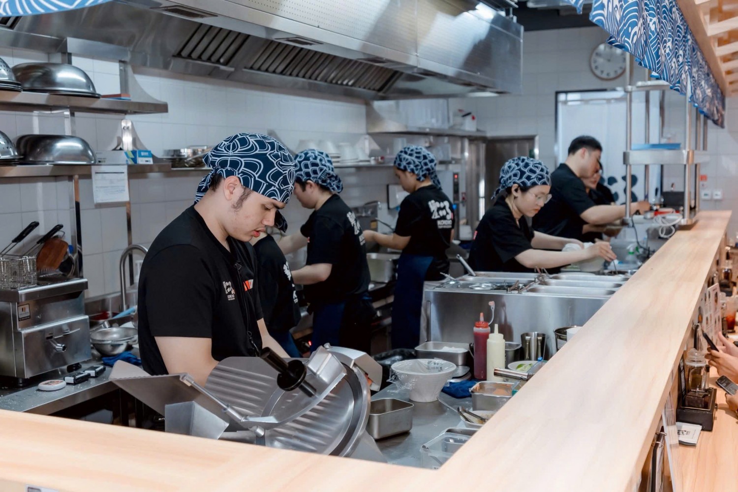 Nhân viên Kokoro mặc áo thun đồng phục màu đen trong khu bếp nhà hàng