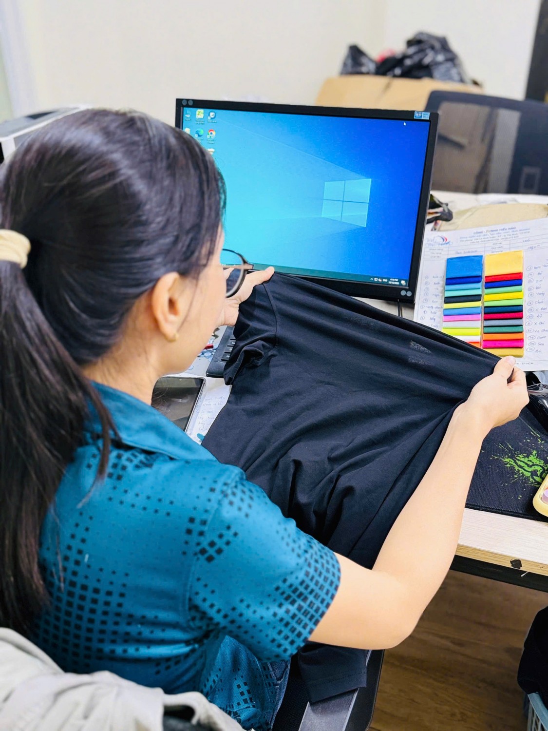 Nhân viên Kim Vàng kiểm tra form và độ co giãn áo thun cotton màu đen