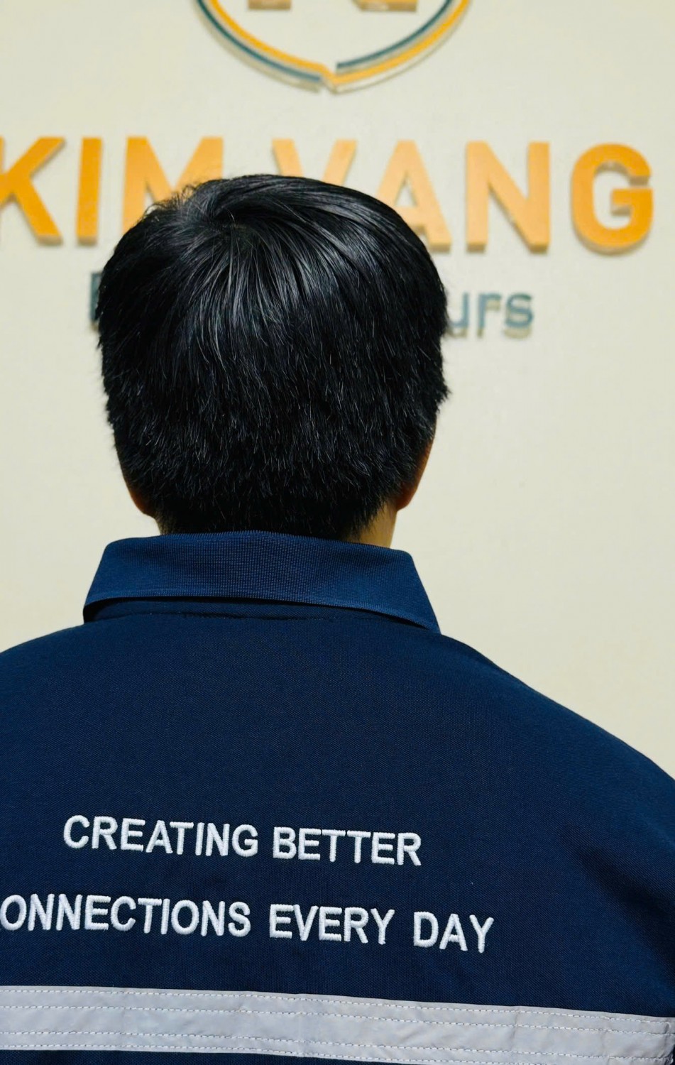 Form áo polo Yusen Logistics nhìn từ phía sau trên người mặc.