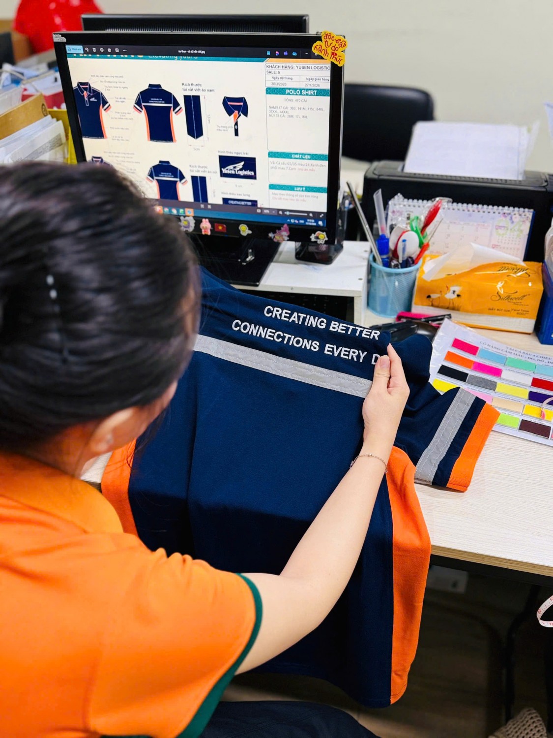 Cận đường may dải phản quang màu bạc trên áo polo xanh cam Yusen.
