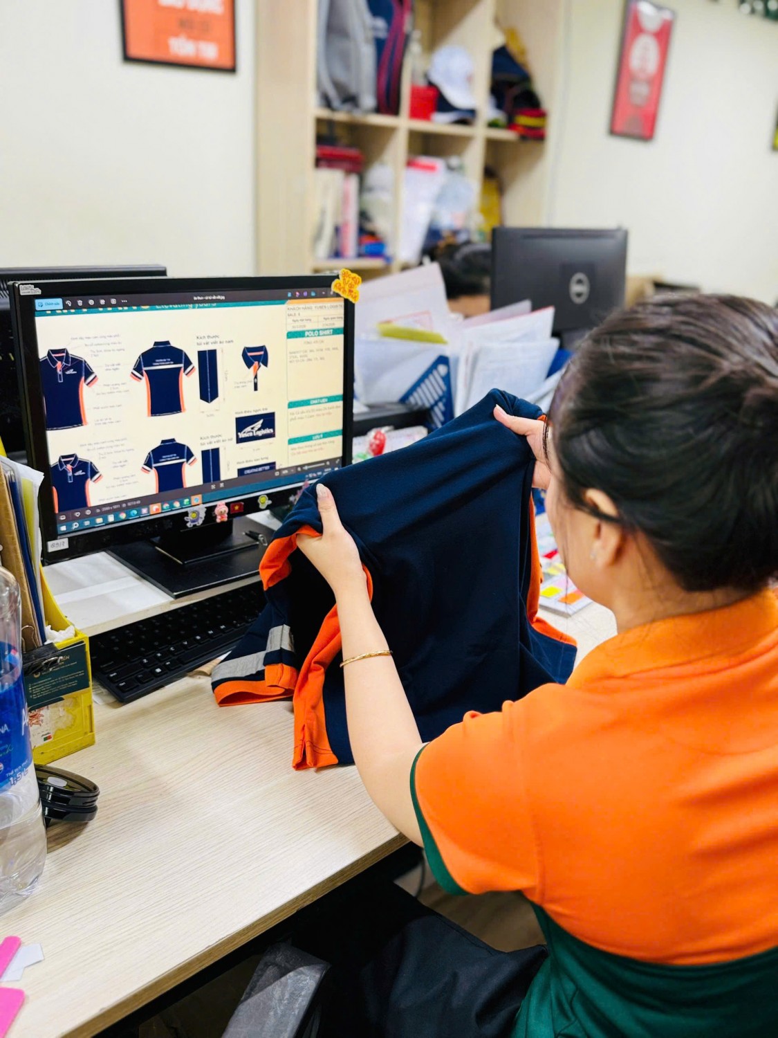 Kim Vàng kiểm tra phần lưng và thông điệp thêu trên áo Yusen Logistics.