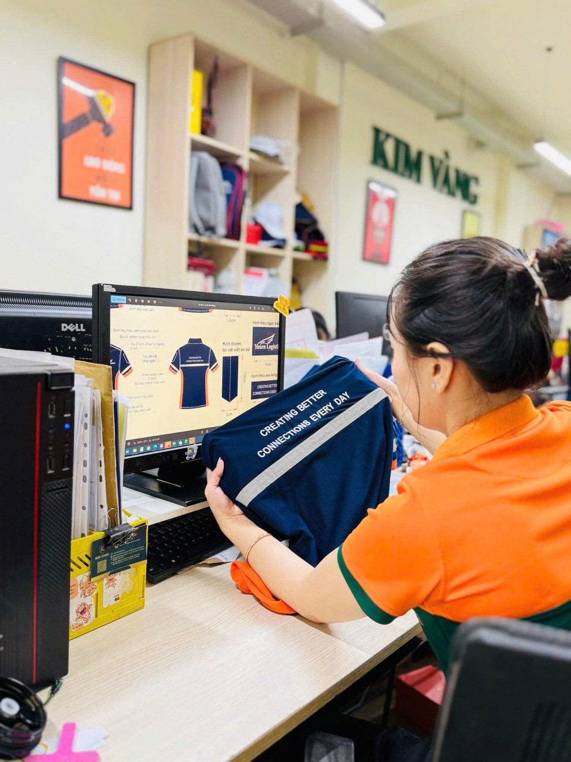 1Nhân viên Kim Vàng kiểm tra thông điệp Creating Better Connections Every Day trên lưng áo Yusen.