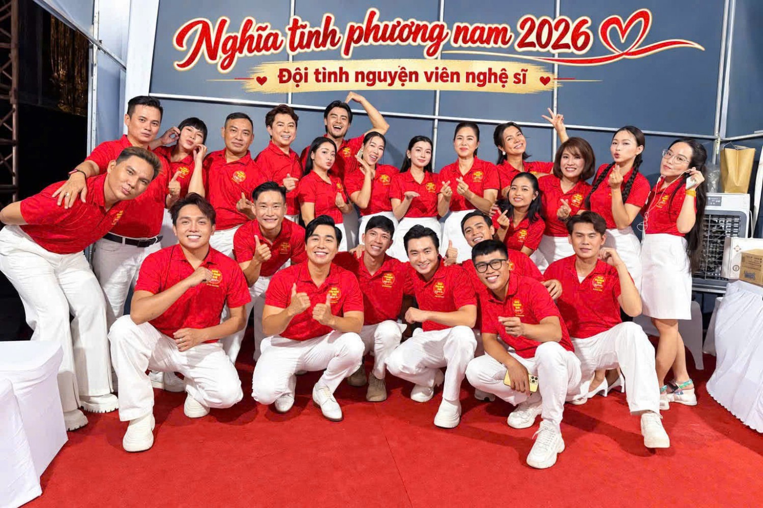 Tập thể tình nguyện viên nghệ sĩ mặc áo polo đỏ tại chương trình Nghĩa tình phương Nam 2026.