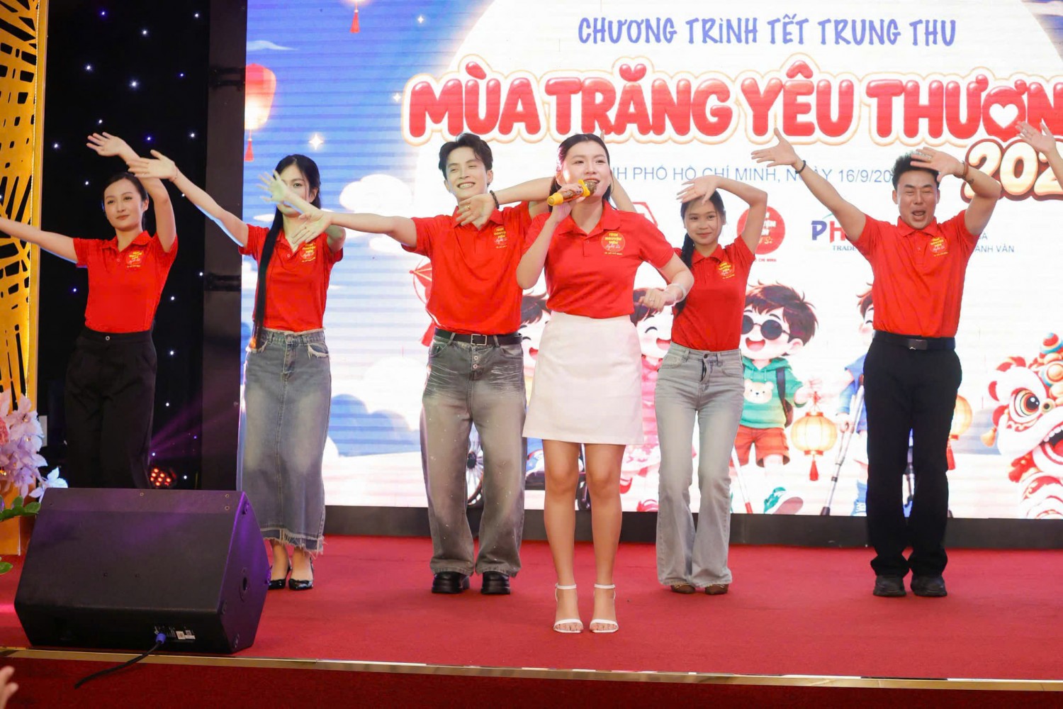 Đội nghệ sĩ mặc áo polo đỏ biểu diễn tại chương trình Mùa trăng yêu thương.