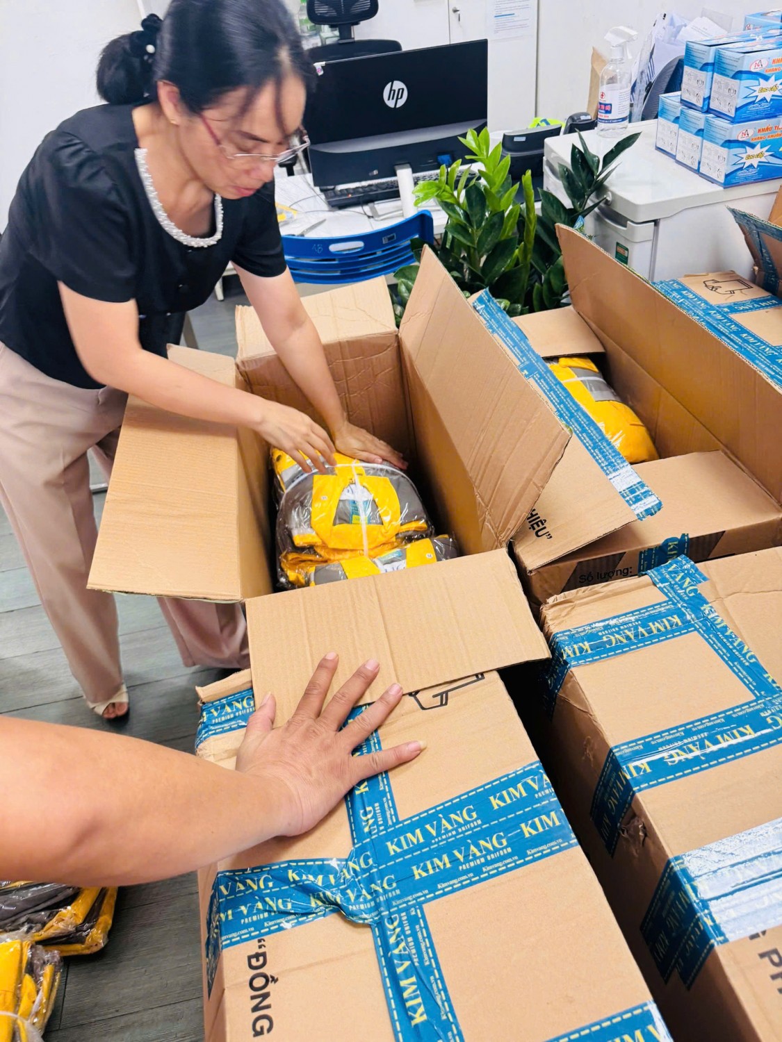 Nhân viên Kim Vàng kiểm tra đồng phục SSIT trong thùng carton.