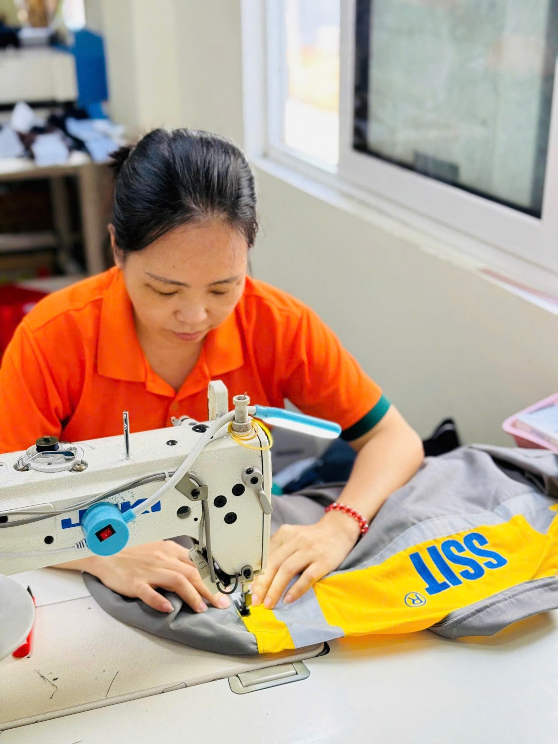 Người thợ Kim Vàng trực tiếp may bộ đồng phục bảo hộ vàng xám SSIT.
