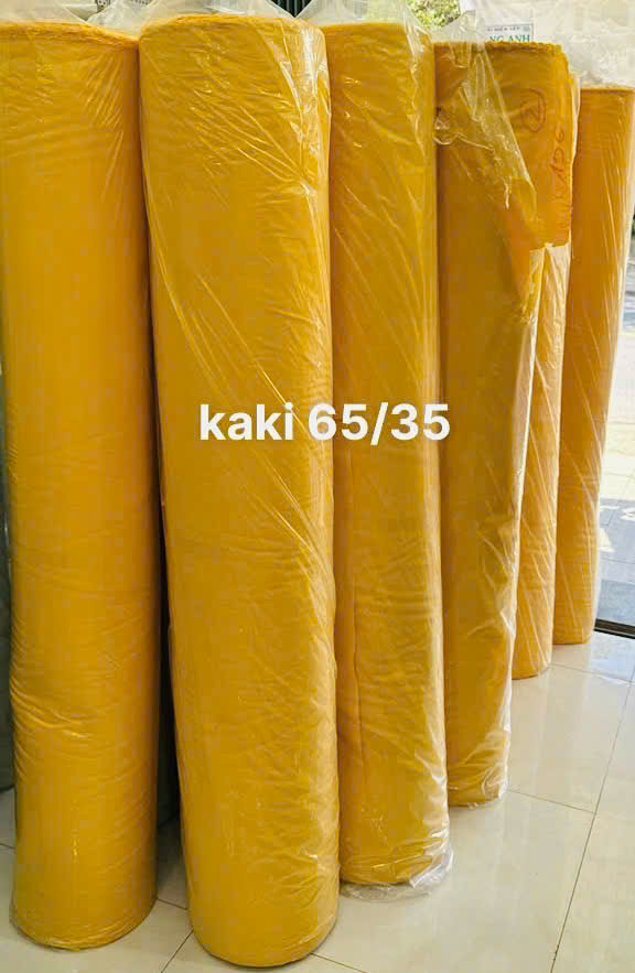 Cây vải kaki màu vàng ghi 65/35 phục vụ lựa chọn nguyên liệu đồng phục.
