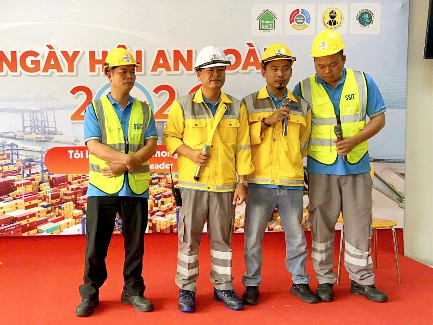 Nhân sự SSIT mặc áo bảo hộ vàng xám và ghi lê hiển thị cao trong hoạt động an toàn.