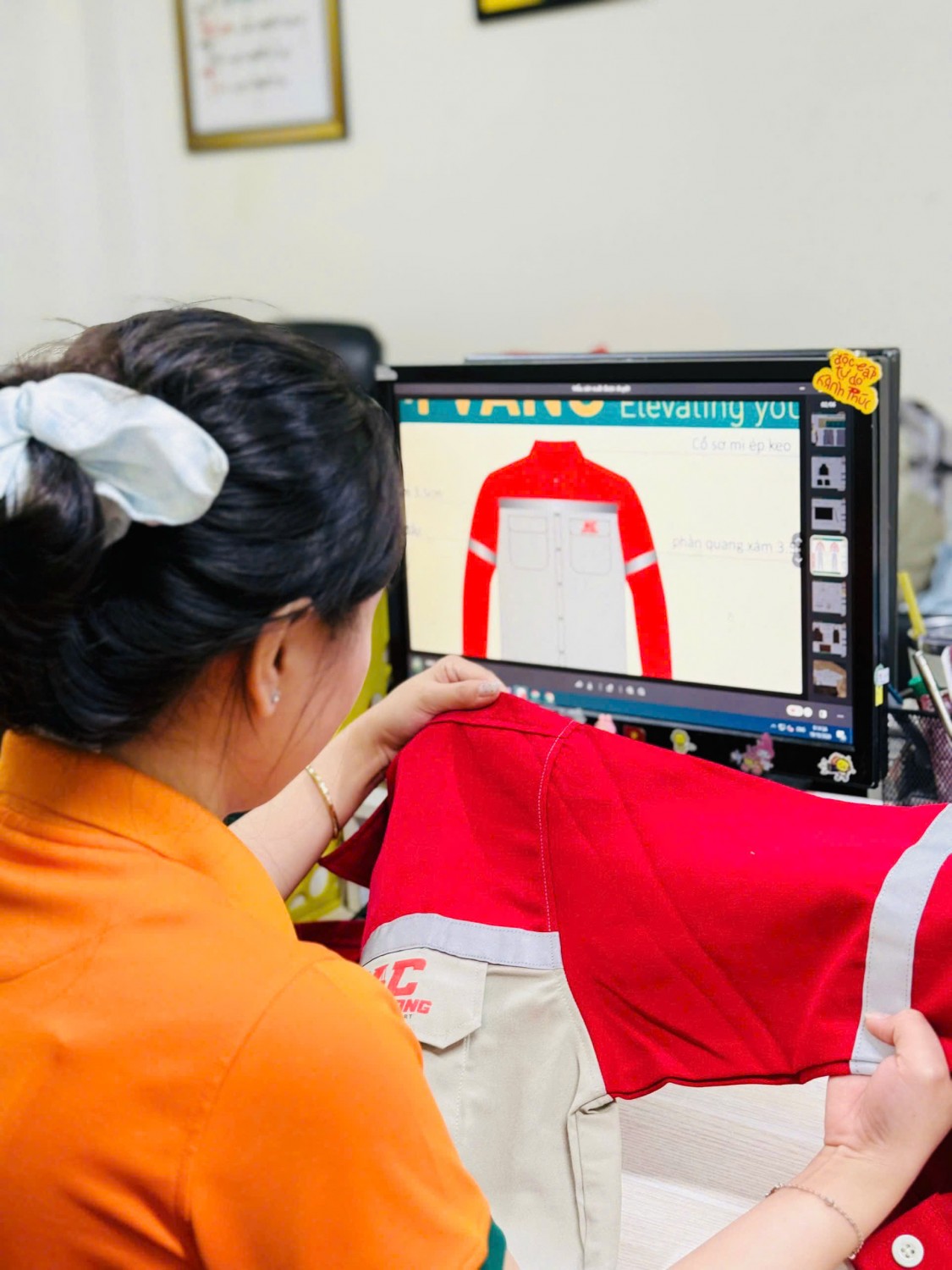Kiểm tra mẫu áo bảo hộ Kiên Cường cạnh bản thiết kế kỹ thuật.