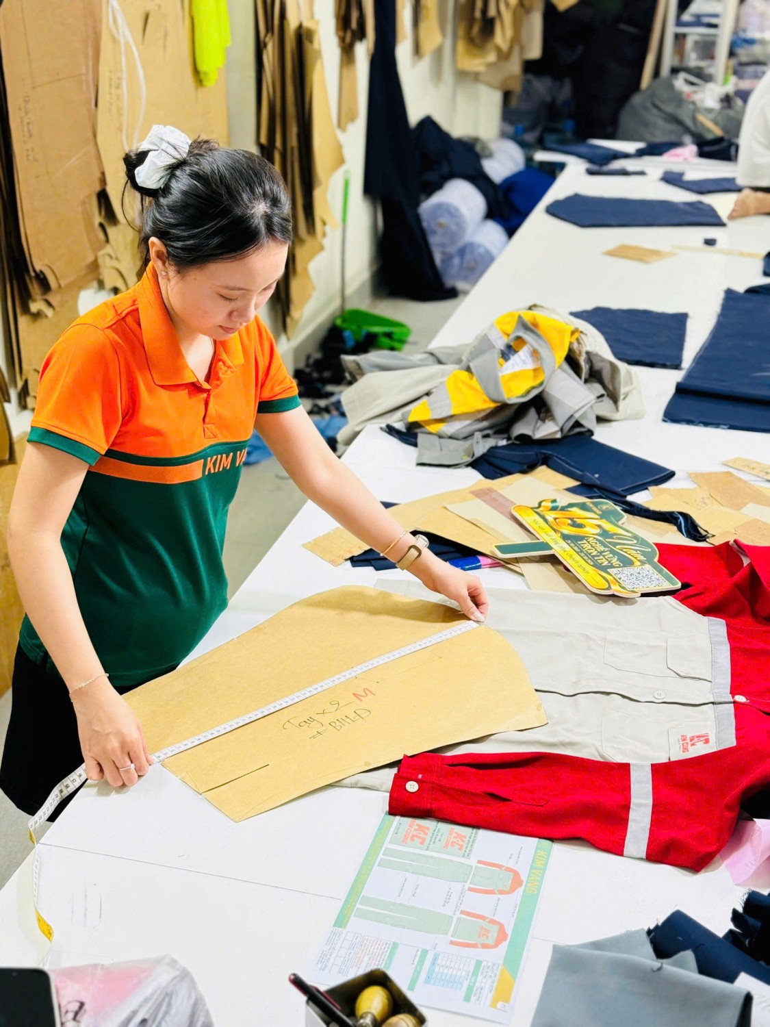 Nhân viên Kim Vàng đối chiếu rập với bộ quần áo bảo hộ Kiên Cường.