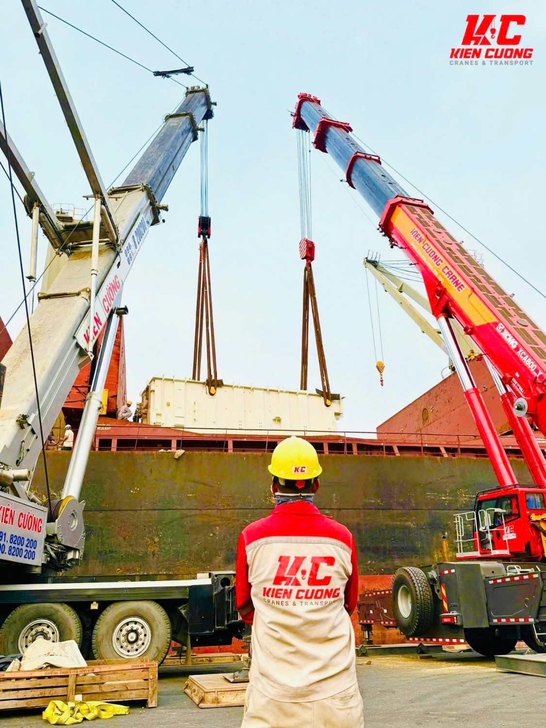 Người lao động Kiên Cường mặc quần bảo hộ khi giám sát hoạt động cẩu hàng.